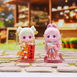 Detail of two cute Hanfu girl figurines with traditional scrolls in a miniature street