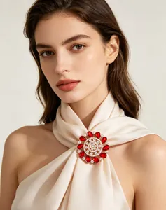 Detailed close-up of a luxury red crystal flower brooch worn on a satin scarf accessory