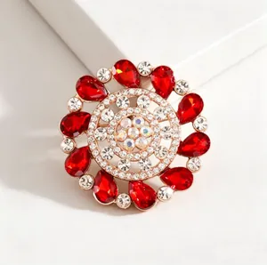 Detailed macro view of vintage gold brooch with red teardrop gems and sparkling diamonds
