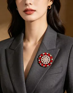 Detailed view of luxury gold flower brooch with red stones on a grey blazer
