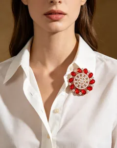 Detailed view of luxury brooch with red teardrop crystals on white lapel shirt
