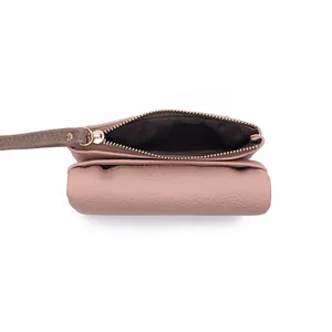 Detail view of the pink lychee leather wallet featuring golden zipper and hand strap