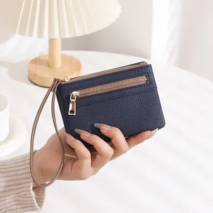 Detailed view of deep blue litchi grain leather wallet with double gold zippers