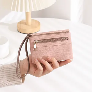 Detail showing pink pebble leather texture on a compact double zipper wristlet wallet
