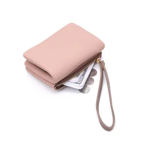 Detail of pink pebbled leather coin purse with triple compartments and wrist strap