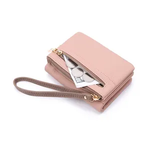 Pink pebbled leather wallet detail showing zipper pocket for coins and folded bills