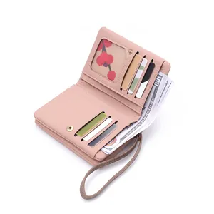 Close-up of pink leather wallet with card slots, ID window and detachable wristlet strap