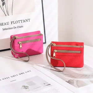 Detail view of double-zippered women's wallets with lychee texture and wristlet straps