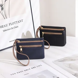 Detail of navy and black double zipper wallets featuring premium lychee grain texture