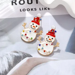 Detail of Christmas snowman stud earrings with enamel finish and colorful rhinestones