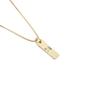 Detailaufnahme eines goldenen Rechteck-Anhängers mit buntem Zirkon-Buchstabe M auf Boxkette