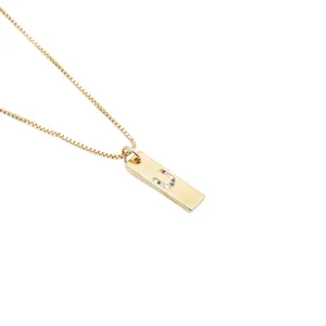 Detailaufnahme der goldenen Halskette mit rechteckigem Anhänger und Zirkon-Buchstaben U