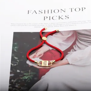 Detail of red braided bracelet with gold G initial charm and adjustable slide clasp