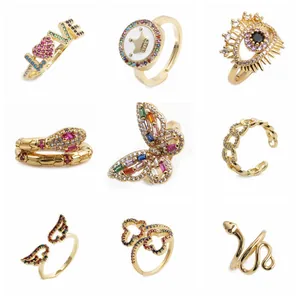 Détail de neuf bagues dorées avec zircons colorés et motifs de papillons bohèmes chic