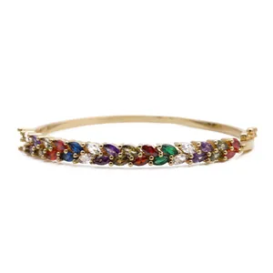 Macro detail of gold-plated bangle featuring colorful marquise-cut marquise stones