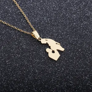 Macro detail of gold-plated stainless steel necklace with a hollow mother-child pendant