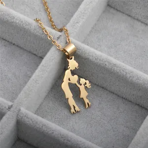 Macro shot of minimalist gold mother and child silhouette pendant on a delicate chain