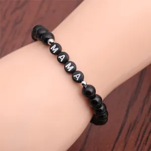 Macro detail of MAMA beaded bracelet featuring black glossy agate stones on a wrist