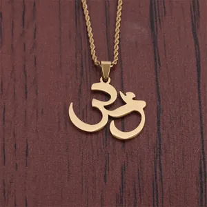 Golden titanium steel Indian Om symbol pendant with twisted rope chain on wood background
