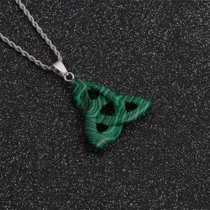 Macro view of a green malachite triquetra pendant on a silver rope chain necklace