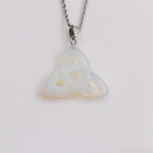 Macro shot of an opal triquetra pendant on a silver rope chain with a minimalist design