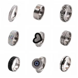 Collage of stainless steel rings featuring Greek key, chain links, and enamel eye designs