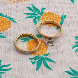 Detailed view of silver and gold toned couple rings with a sparkling zircon inlay