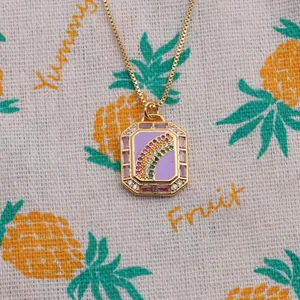 Macro view of gold plated octagonal pendant with rainbow zircon and purple enamel