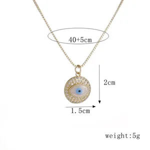 Detail van de gouden evil eye hanger met blauwe zirkoon en fijne kwastjes ketting
