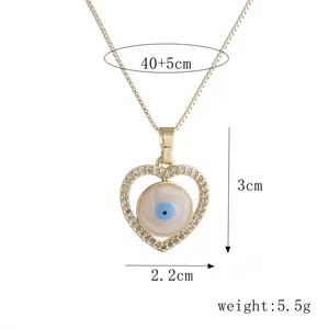 Detailopname van gouden boze oog hart hanger met afmetingen 3cm x 2.2cm en specificaties