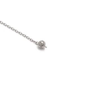 Macro shot of silver hollow patterned metal bead with classic O-ring chain and reflection