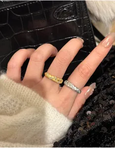 Macro detail of braided wheat pattern ring with inlaid small diamonds on finger