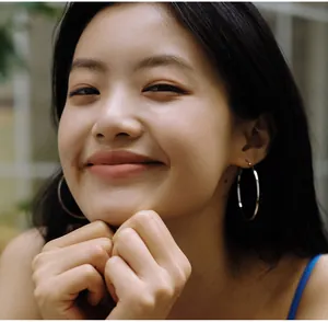 Close-up of polished silver hoop earrings worn by a model in natural light