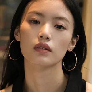 Minimalist large rose gold hoop earrings worn by a model for a stylish luxury look