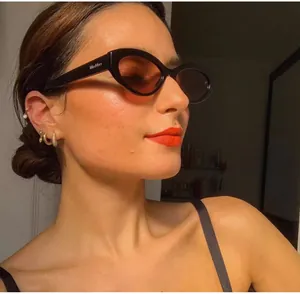 Close-up of elegant gold hoop earrings and ear cuff on model with retro black sunglasses