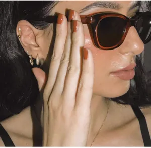 Detailed view of luxury gold crystal hoop earrings with retro tortoiseshell sunglasses