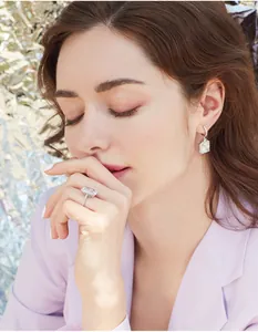 Close-up of luxury square-cut diamond ring and matching earrings on a model