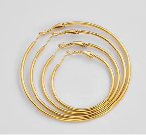 Detail view of four graduated sizes of polished gold titanium hoop earrings set
