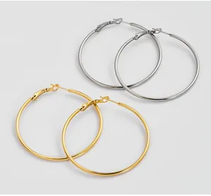 Macro shot of large polished hoop earrings in gold and silver with secure lever-back clasps