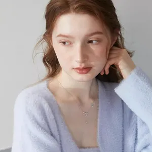 Elegante collana con ciondolo a fiocco argento e pietre luccicanti indossata da una modella