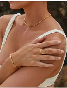 Golden rope chain necklace and minimalist geometric ring set on sun-kissed skin