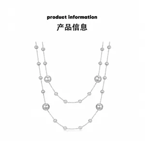 Detail view of double-layered pearl necklace with polished silver chains and beads