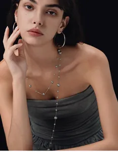Nahaufnahme einer eleganten silbernen Perlenkette und großer Creolen an einem Model