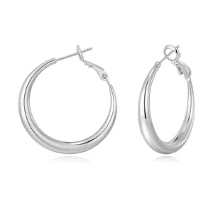 Detailed view of silver hoop earrings with gradient thickness and polished metal finish