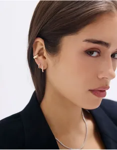 Détails de créoles dorées avec micro-pavage et collier tennis en cristal sur un mannequin