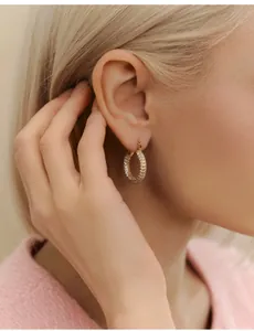 Close-up of luxury gold-plated hoop earrings with micro-pave white zircon crystals