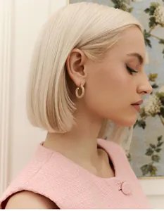 Close-up of luxury gold hoop earrings with pavé crystals on elegant model