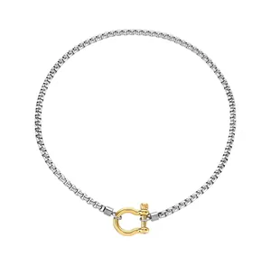 Détail du collier à chaîne argentée avec un fermoir à boucle en fer à cheval doré