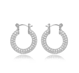 Close-up of luxury micro-paved crystal hoop earrings with polished silver finish