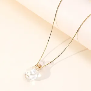 Detailed view of an 18K gold box chain with a crystal perfume bottle shaped pendant